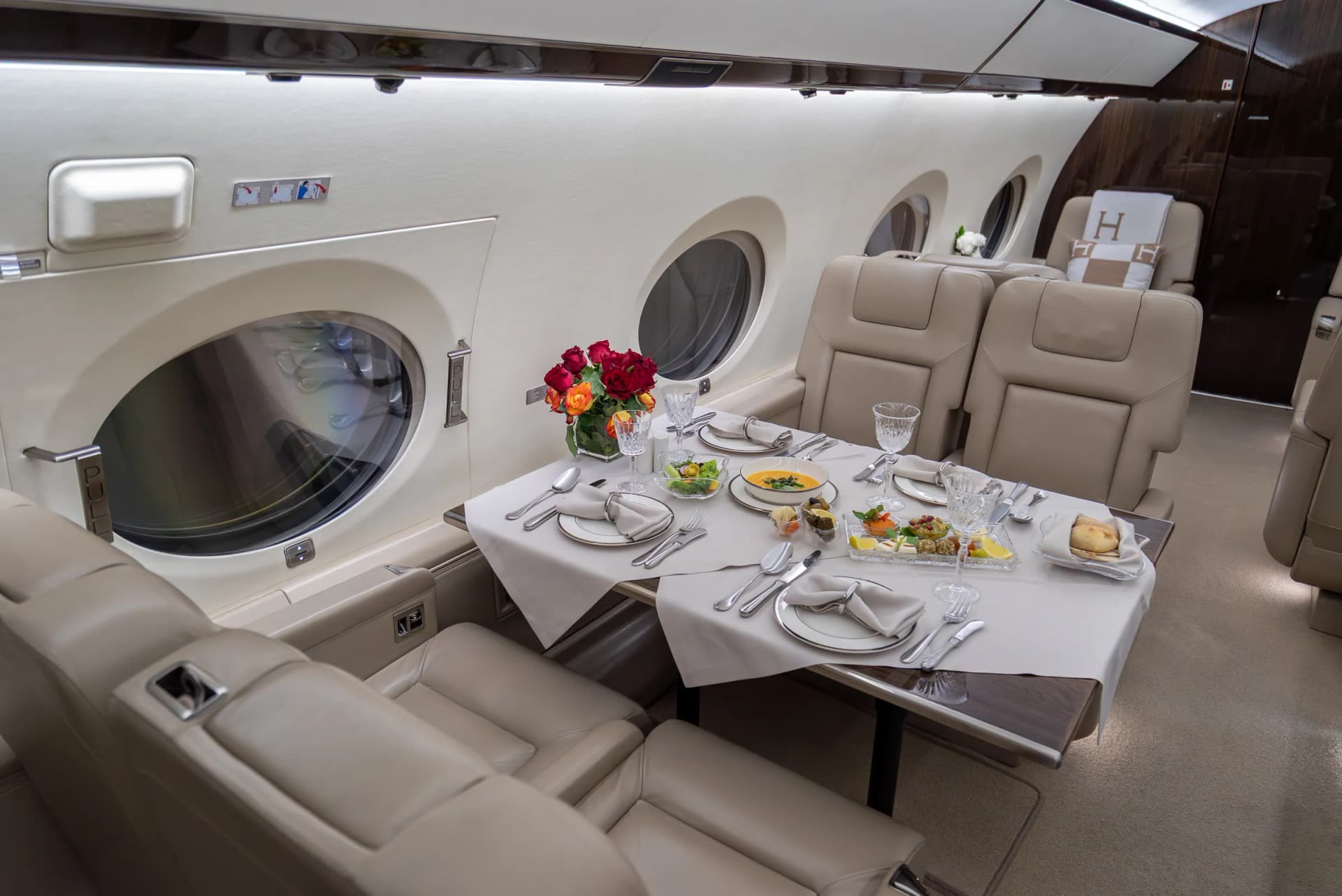 Breakfast laid for four at the Gulfstream G450 conference table, with roses by the window