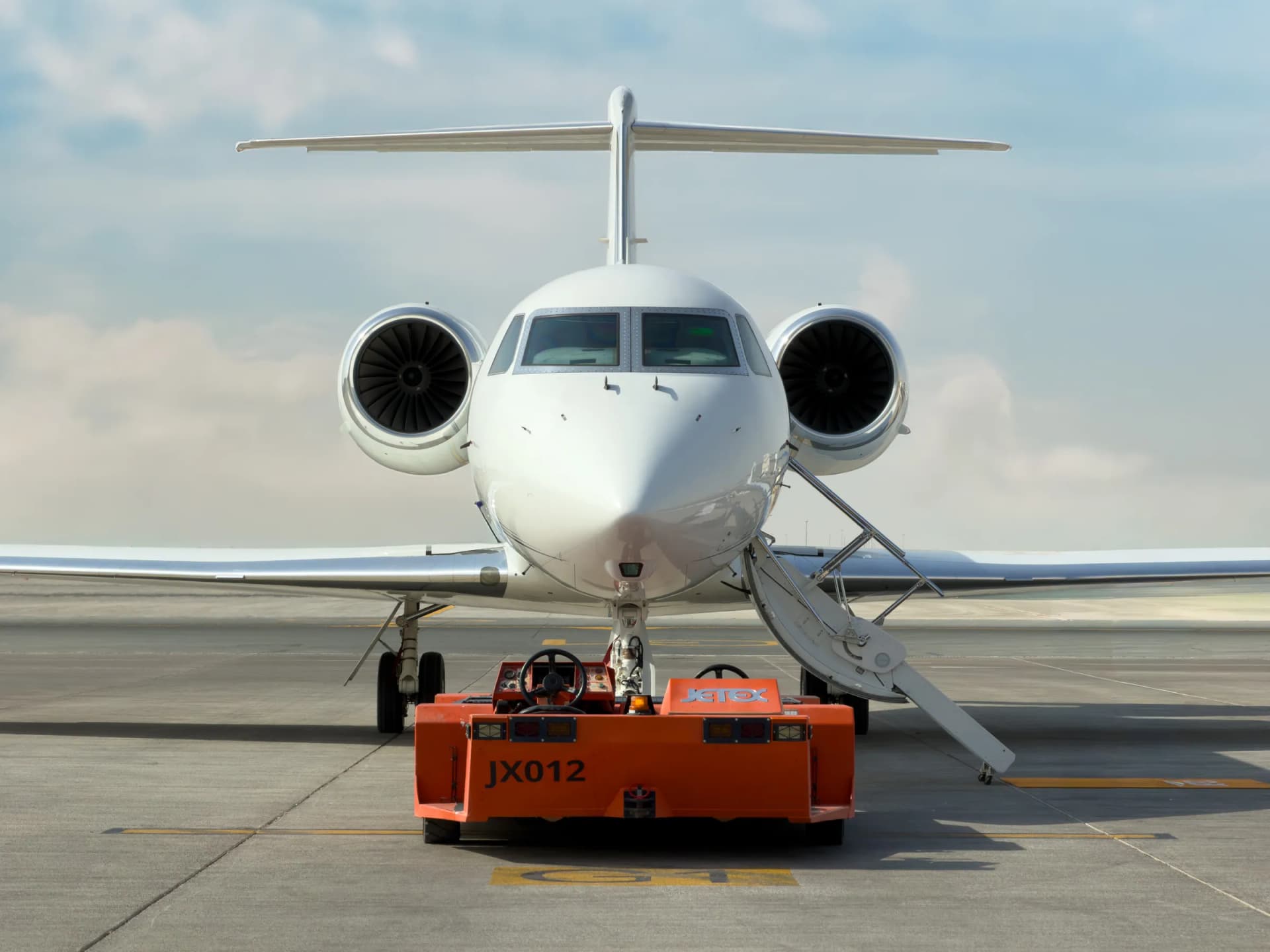 Gulfstream G450 head-on on the ramp, a tug at the nose gear and the airstair down