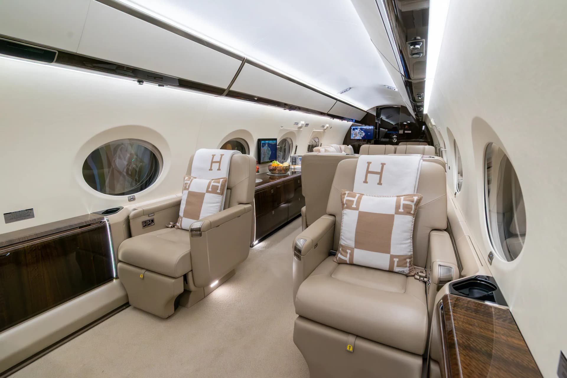 Gulfstream G450 club seats with Hermès cushions beside dark wood cabinetry