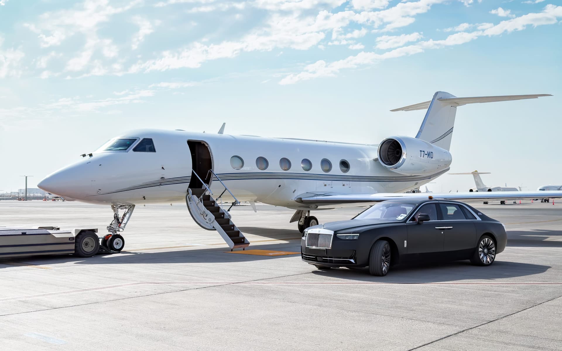 Gulfstream G450 T7-MID on the Dubai ramp with its airstair down beside a waiting Rolls-Royce